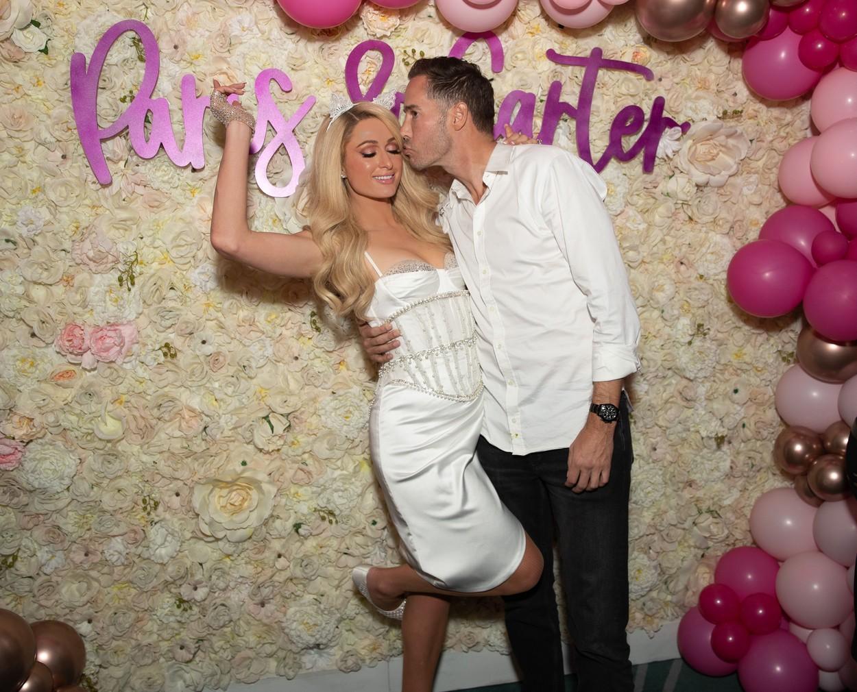 Paris Hilton imbracata intr-o rochie alba alaturi de logodnicul ei Carter Reum inainte de nunta